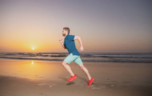 Полная длина здорового человека бегущего и бегущего на свежем воздухе. Бегун. Фитнес-бегун-мужчина во время заката тренировки. — стоковое фото