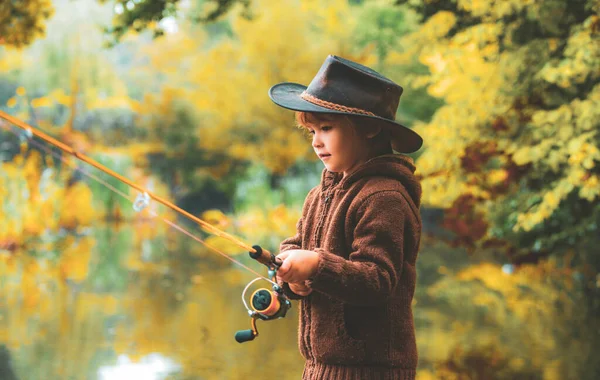 Kinderangeln am Herbstsee. Kind mit Angelrute. — Stockfoto