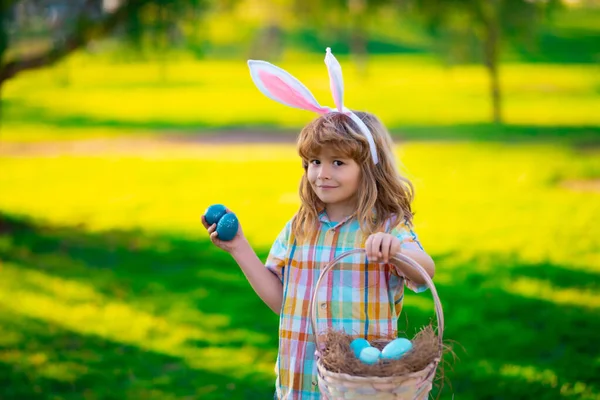 Nyuszifiú. Húsvéti nyuszi gyerekek. Gyerek fiú nyuszifül vadászat húsvéti tojás a parkban szabadban. — Stock Fotó