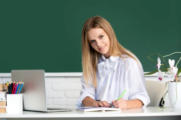 Portrait of smiling young college student writing, studying in classroom. — Stock Photo, Image