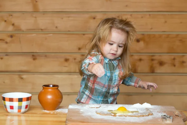 Bebê bonito brincando com farinha na cozinha de madeira. Cozinha infantil. — Fotografia de Stock