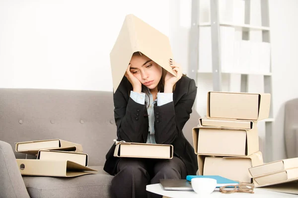 Занятая деловая женщина с папкой на голове, секретарша, работающая одна допоздна. Рассерженная грустная секретарша, расстроенный бухгалтер в офисе. — стоковое фото