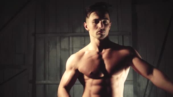 Uomo muscoloso in posa in studio a torso nudo. Un tipo con una camicia nera, un giovane modello maschio. Atleta da un bel corpo forte. — Video Stock