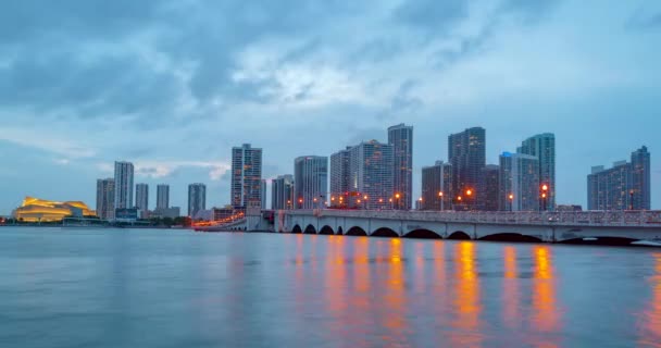 Miami panorama lapso de tiempo. Cielo nocturno timelapse en Miami Beach City. Caducidad de la puesta de sol en el cielo urbano y nubes moviéndose con el reflejo de la ondulación del agua. MacArthur centro, ciudad de la Calzada. — Vídeos de Stock