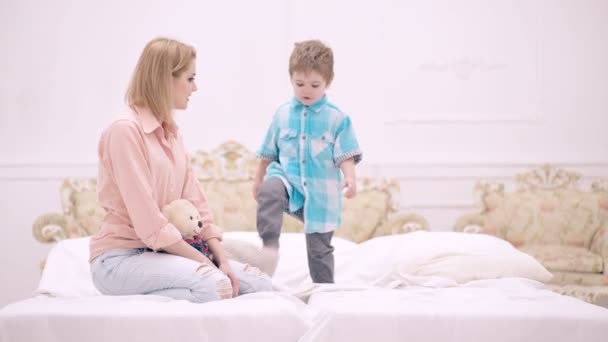 Liebevolle Familie. Mutter spielt mit Kind im Schlafzimmer. Mutter und sohn kind spielen zusammen auf dem bett im haus. — Stockvideo