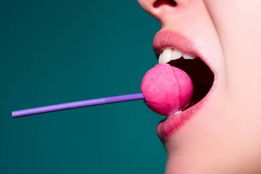 Seksi ağız yalayan lolipop, kırmızı kadın parlak dudaklar ve pembe şeker lolipop..