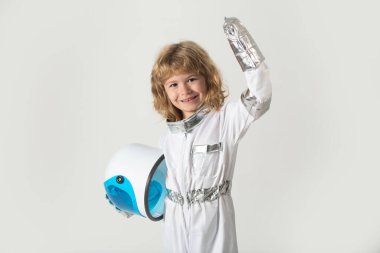 Çocuk elinde kaskla astronotçuluk oynuyor. Küçük mutlu uzay adamı.