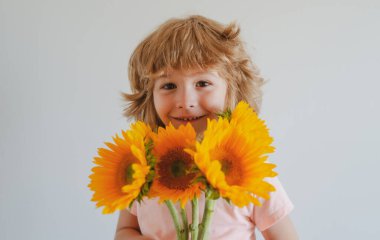 Ayçiçekli gülümseyen çocuk. Bir buket çiçekli mutlu çocuk. Sevimli, sevimli, romantik ve sürpriz..