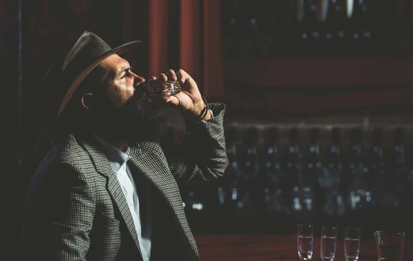 Hipsterski mężczyzna ze stylową brodą pijący piwo siedzący przy barze. — Zdjęcie stockowe