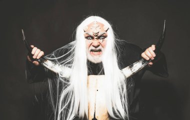 Siyah arka planda bir Druid. Ejderha derisi ve gri sakallı bir uzaylı. Eski simya. Beyaz mavi gözlü canavar. Ağaç ruhu ve fantezi konsepti. Boynuzlu kötü adam.