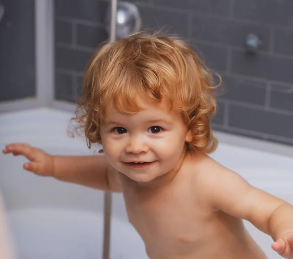 Baby kind wassen in een badkamer in schuim. — Stockfoto