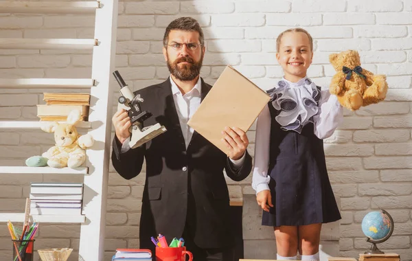 Sınıfta öğretmen olan ilkokul öğrencisi. İlkokulda genç bir kız öğrenciyle öğretmen..