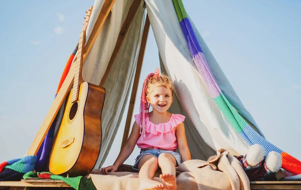 Miúdo sorridente na tenda. Rapariga a brincar no acampamento. Crianças a acampar. A divertir-se ao ar livre. Campo de campismo. — Fotografia de Stock