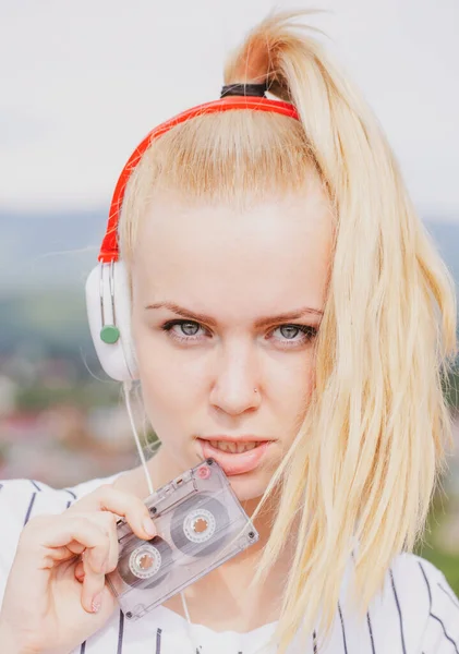 Žena poslouchající hudbu s kazetou a sluchátky. Emocionální portrétní dívka. Retro hráč. — Stock fotografie