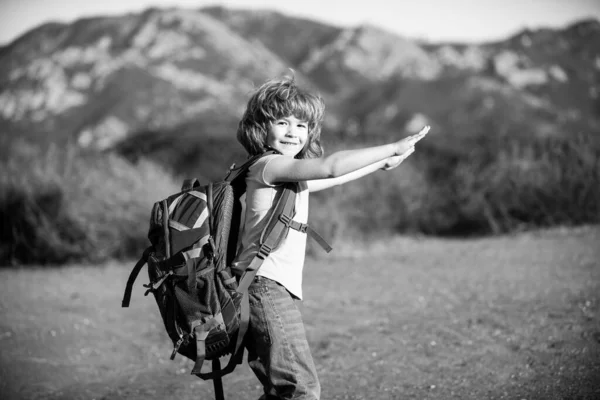Sırt çantalı küçük bir çocuk manzaralı dağlarda yürüyüş yapıyor. Çocuk turist yerel bir yürüyüşe çıkıyor. — Stok fotoğraf
