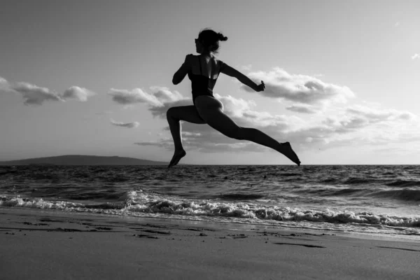 La mujer corre a la playa. Chica deportiva activa corriendo a lo largo del océano surf junto a la piscina de agua para mantenerse en forma y la salud. Mujer fitness, ejercicio de jogging y actividad deportiva en vacaciones de verano. — Foto de Stock