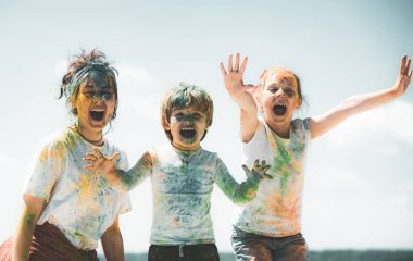 Komik çocuklar yüzlerine renk sıçratır, çocuk vücuduna renkli pudra sürer. Parlak renklerle boyanmış ellerini gösteren neşeli arkadaşlar. Renkli kirli insanlar..