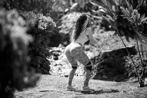 Fitness femme faisant de l'exercice pour les fessiers avec bande de résistance dans le parc. Belles fesses, fille athlétique travaillant sur. — Photo