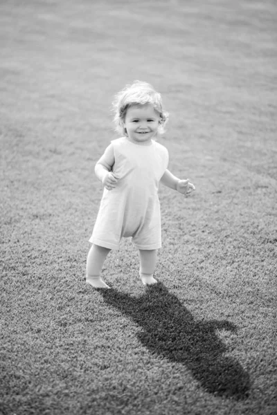 Bebé niño pequeño caminando en un parque en brillante día de primavera. —  Fotos de Stock