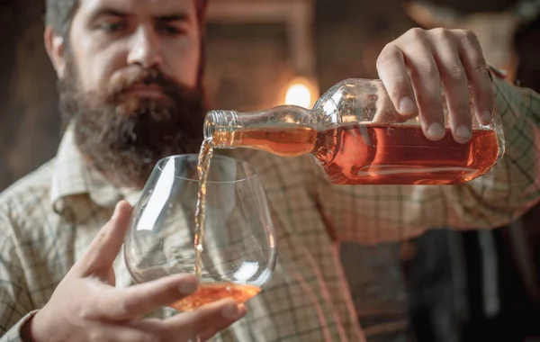 Degustační ochutnávka. Muž s plnovousem drží Sklenka brandy. — Stock fotografie