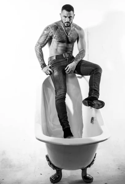 Na banheira. Sim. Homem hispânico barbudo com torso muscular sentado na borda do banho. Brutal latino homem relaxante no banho. Banheira de hidromassagem e jacuzzi — Fotografia de Stock