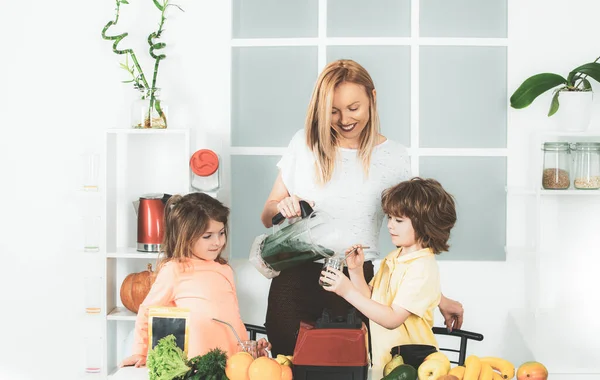 Anne kız ve oğlu mutfakta bir smoothie hazırlıyorlar. İyi eğlenceler ve sebzelerle oynayın. Sağlıklı beslenme ve çocuklar için yaşam tarzı. Vejetaryen beslenmesi ve sağlıklı bir yaşam tarzı. Mutlu sevgi dolu aile. — Stok fotoğraf