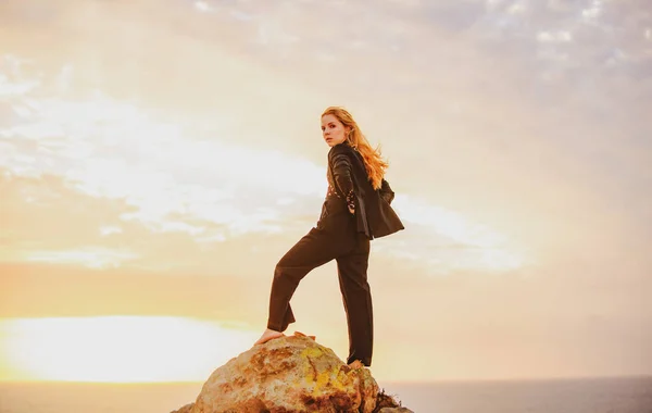 Ganadora o líder empresaria despreocupada. Chica de negocios en el acantilado con hermosa vista en la salida del sol puesta del sol. Cielo con nubes en las montañas sobre el fondo del paisaje. — Foto de Stock