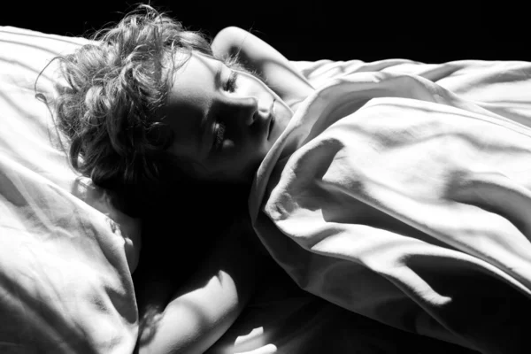 Criança calma dormindo em cama confortável deitada no colchão ortopédico travesseiro macio, criança bonito descansando coberto com cobertor em lençóis no quarto, vista superior. — Fotografia de Stock