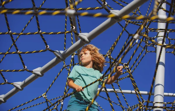 Happy little child boy on the web in outdoor playground. — Stock Photo, Image