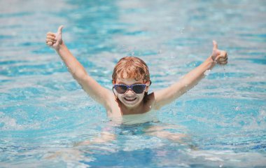 Heyecanlı çocuk yazın yüzme havuzunda rahatlar. Çocuklar tropikal tatil köylerinde oynarlar. Aile plaj tatili.