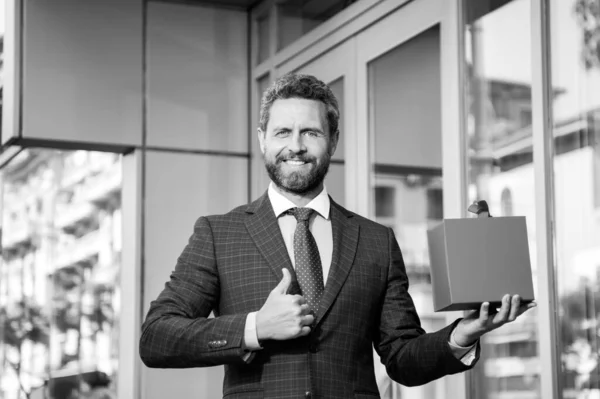 Affärsman utomhus med shoppingväska. Snygg man med födelsedagspresent. Tummen upp. Jubileumsfirande. Hälsningar på helgerna. Presentbutik. — Stockfoto