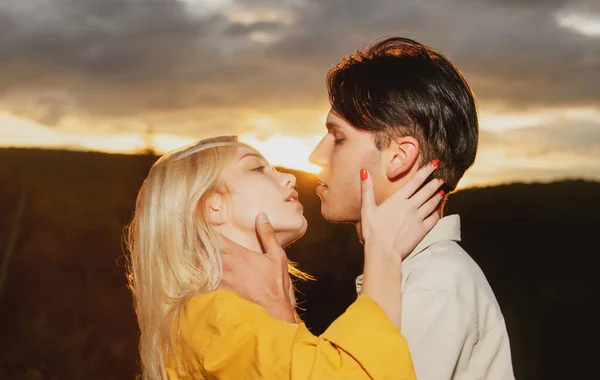 Amantes jóvenes abrazándose y abrazándose. Abrazos de una pareja amorosa al atardecer. Pareja enamorada ternura y afecto. —  Fotos de Stock