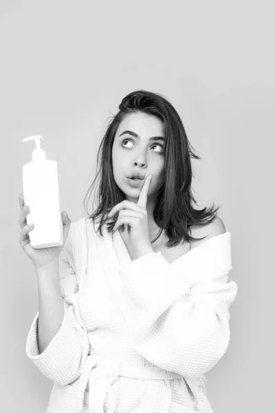 Překvapená překvapená žena držet láhev šampon a kondicionér. — Stock fotografie