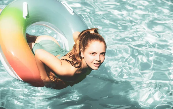 Fille heureuse jouant avec anneau de natation coloré dans la piscine. Une jeune femme joue dans une station tropicale. Vacances à la plage en famille et activité estivale. Vacances d'été fun. — Photo