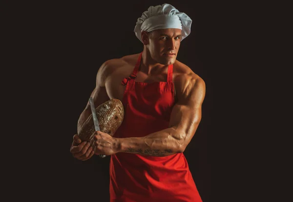 パン屋さん。パンとナイフを持つセクシーな男。料理と焼き. — ストック写真