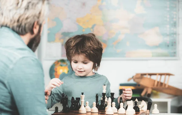 Geconcentreerde jongen die schaakstrategie ontwikkelt, bordspel speelt. Kind en jeugd. — Stockfoto