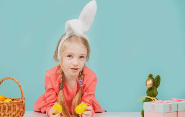 Пасхальная девушка с цветными яйцами. Весенняя праздничная концепция. Счастливый малыш в кроличьих ушах на празднике. — стоковое фото