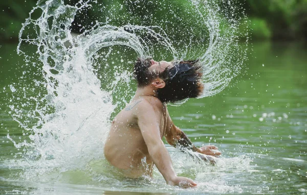 濡れた髪とひげ。自由の夏の概念。慎重かつ積極的な考え方。髭を生やした男が髪で水を撒いた。夏休み. — ストック写真