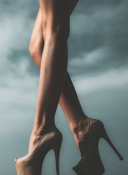 Modefoto der schönen eleganten Frau Beine mit Absätzen. Weibliche Beine mit schwarzen High Heels auf himmelblauem Hintergrund. — Stockfoto