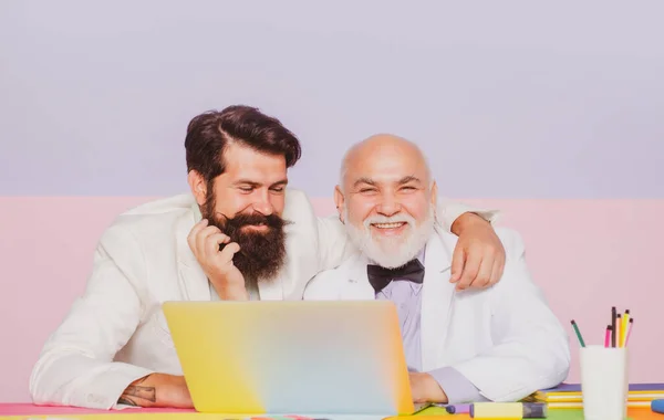 Famiglia felice di uomini d'affari che ridono dell'ufficio. Vecchio uomo d'affari che lavora con il dispositivo del computer portatile sul posto di lavoro. Uomini d'affari nonno condivisione di esperienze sul lavoro. — Foto Stock