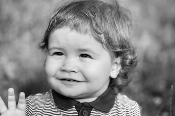 Portrait of little baby boy. Concept of kids face close-up. Head shoot children portrait in summer nature park. Stock Picture