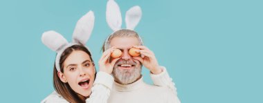 Paskalya çifti. Paskalya yumurtalı mutlu bir çift. Komik tavşanlı pankart, kopyalama alanı.