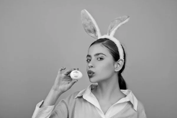 Lippen en Pasen, lippenstift kus afdruk op paasei. Vrolijk Pasen. Jonge vrouw in konijn bunny oren. Portret van een gelukkige vrouw in bunny oren. Eieren zoeken. — Stockfoto