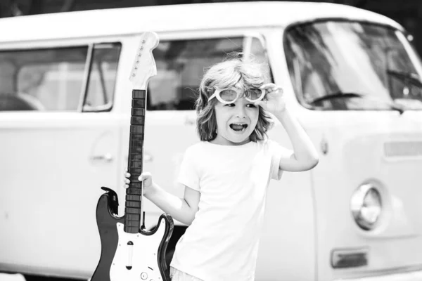 Future rock star. Excited child in pink shirt with electric guitar over pink background. Kids music. — Stock Photo, Image