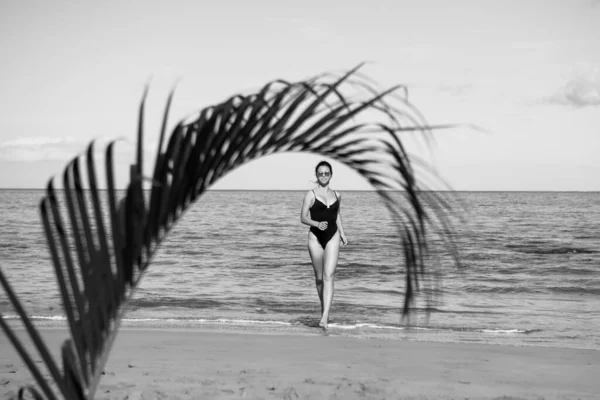 Tropická pláž. Mladá šťastná žena běhá bosá po pláži. Letní pláž a moře. — Stock fotografie