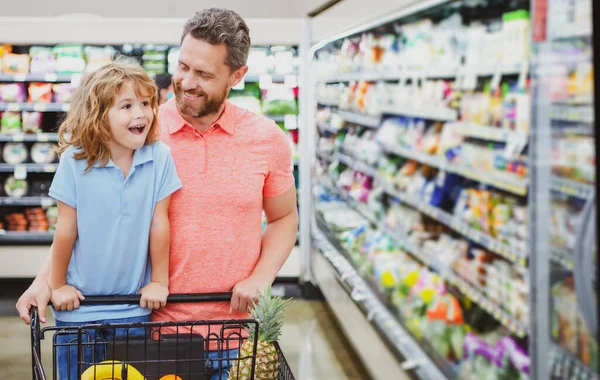 Padre e figlio che guardano il prodotto al supermercato. Papà con bambino al supermercato comprare cibo. — Foto Stock