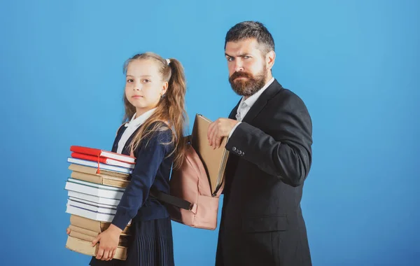 Little school girl hold big stack school textbook notebook books. Father teacher helping to pupil, preparing backpack with school supplies. Educational concept for school. — Stock Photo, Image
