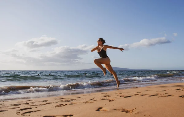 シルエットを動かす女。海上を走る。ビーチコンセプトでスポーツ演習. — ストック写真