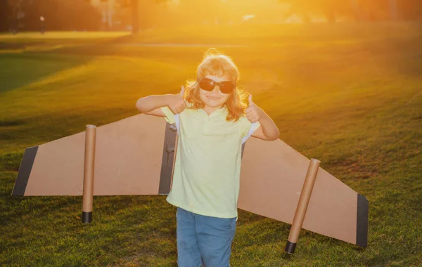 Barnpojken leker och drömmer om sommarsemester och reser i solnedgången. Barn fantasi och frihet koncept. — Stockfoto