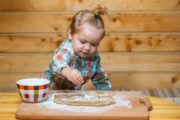 Imagem divertida do bebê chef jogar com farinha no fundo da cozinha de madeira. Adorável pouco cozinhar pastelaria caseira. — Fotografia de Stock